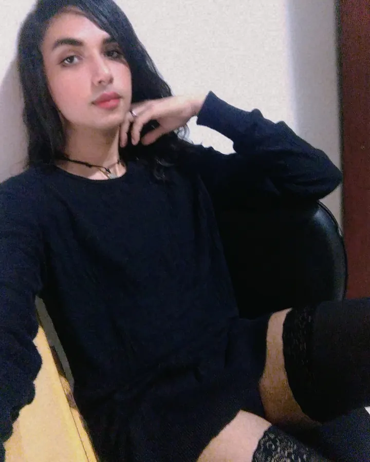 Femme aux cheveux noirs, regard direct, prenant un selfie dans un miroir, visage partiellement visible
