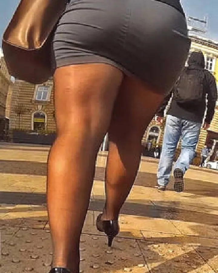 Femme arabe de 45-60 ans, cheveux bruns-noirs, portant un string noir, debout près d'un mur blanc.